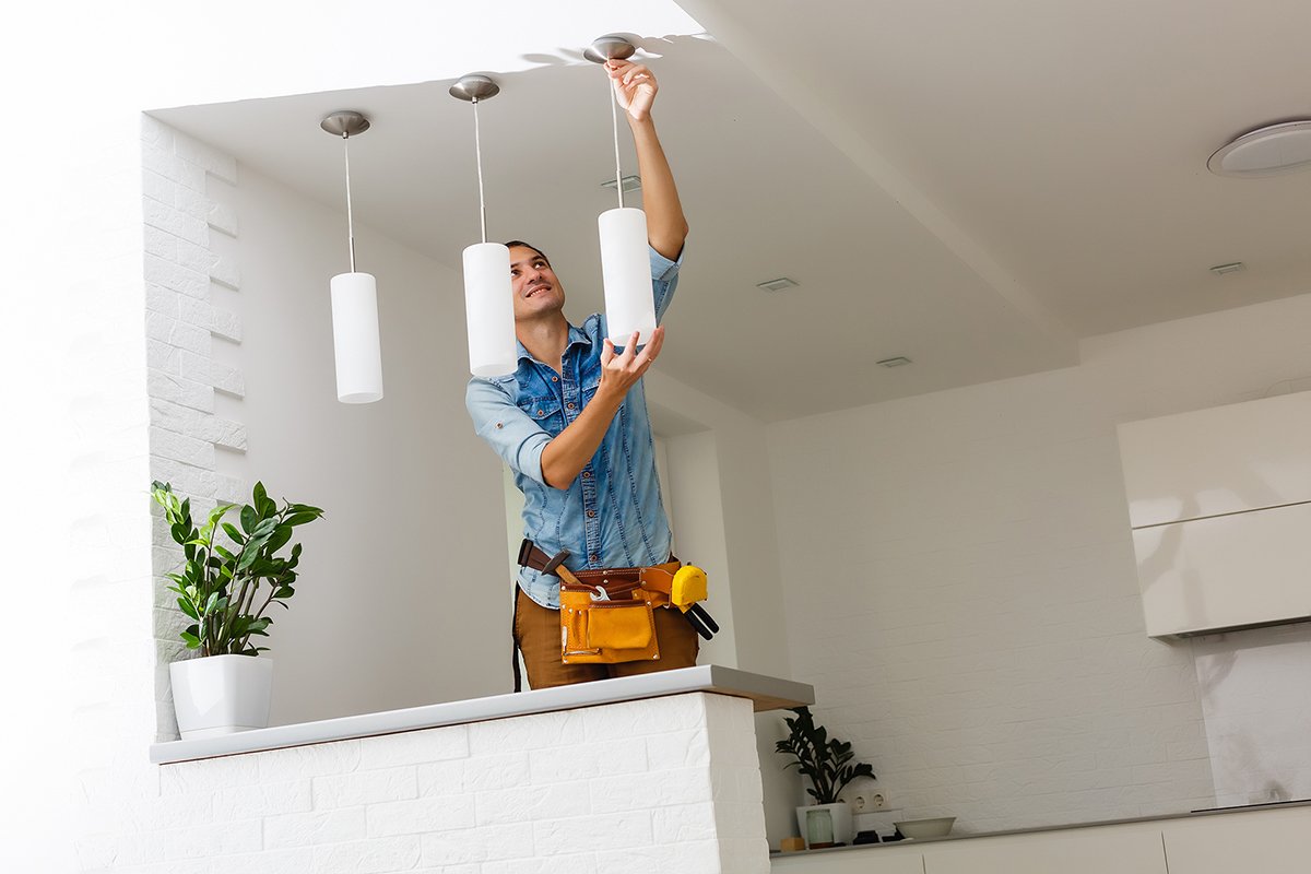 Electrician is installing and connecting a lamp to a ceiling Electrician is installing and connecting a lamp to a ceiling.